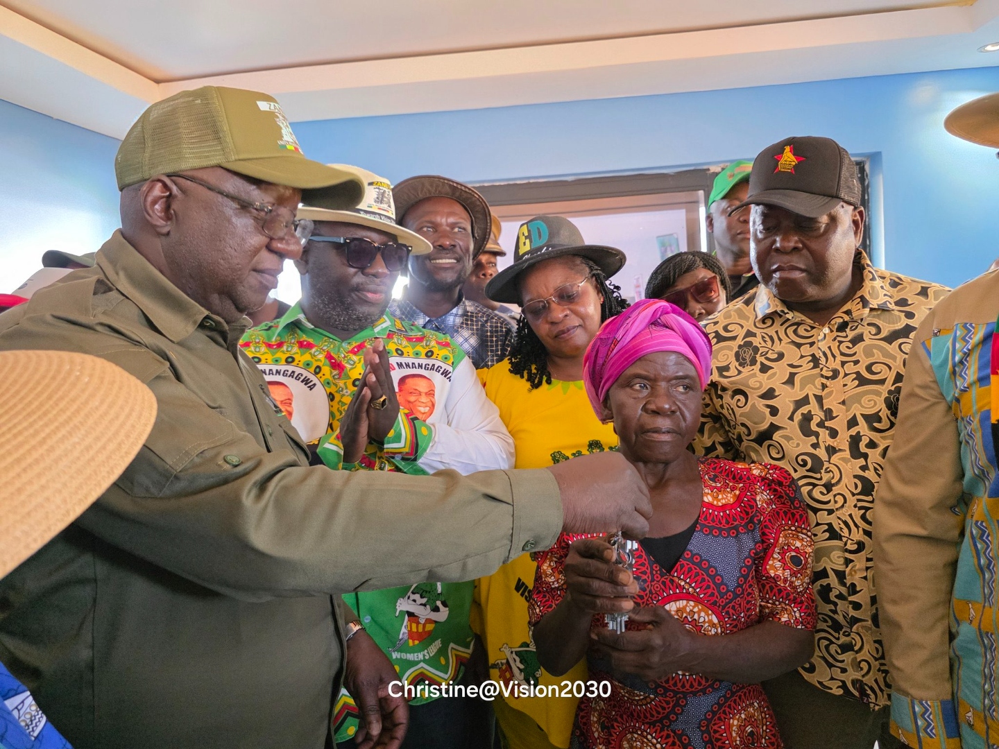 Dr Paul Tungwarara handing house keys to an elderly war veteran beneficiary alongside President Mnangagwa
